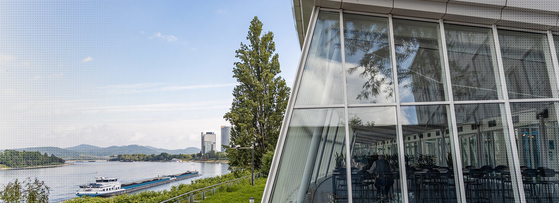 Das Bild zeigt das Geb&auml;ude des Hauptsitzes des Bundesrechnungshofes in Bonn neben dem Rhein und mit Blick auf das Siebengebirge.