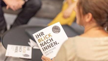 Eine Frau h&auml;lt den Imageflyer des Bundesrechnungshofes "Ihr Blick nach innen" in der Hand.