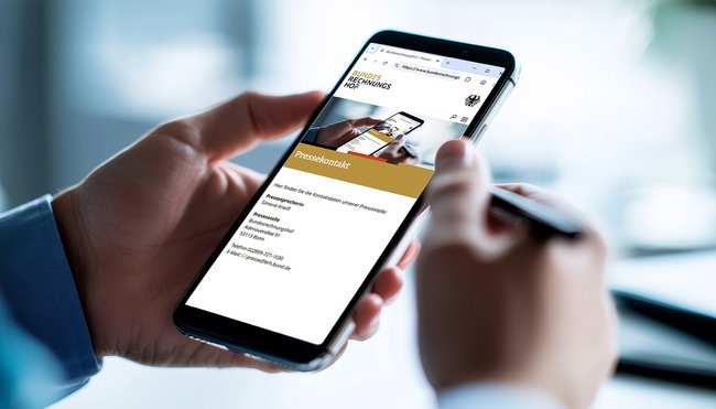 Header Pressekontakt Eine Person gibt etwas auf einem Handy ein.