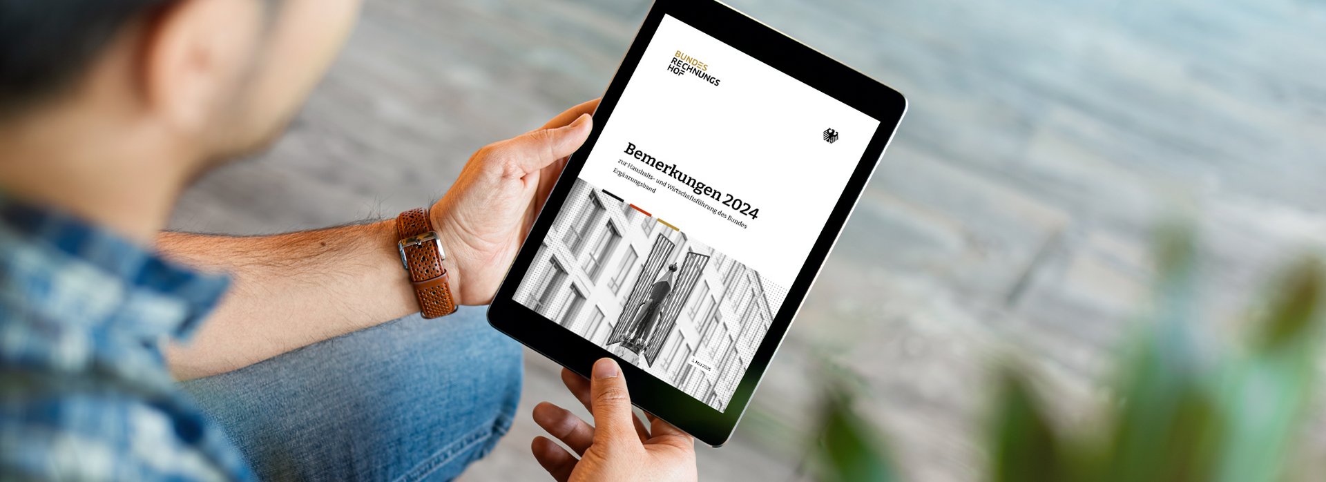 Ein von einem Mann gehaltenes Tablet zeigt einen Ausschnitt aus dem Ergänzungsband der Bemerkungen 2024 des Bundesrechnungshofes.