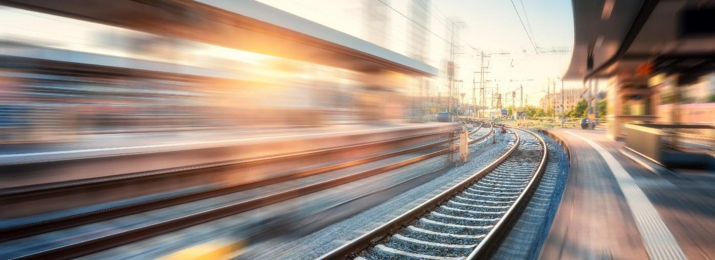 Eine Fotografie eines leeren Bahngleises in der Abendd&auml;mmerung auf einem Bahnhof.