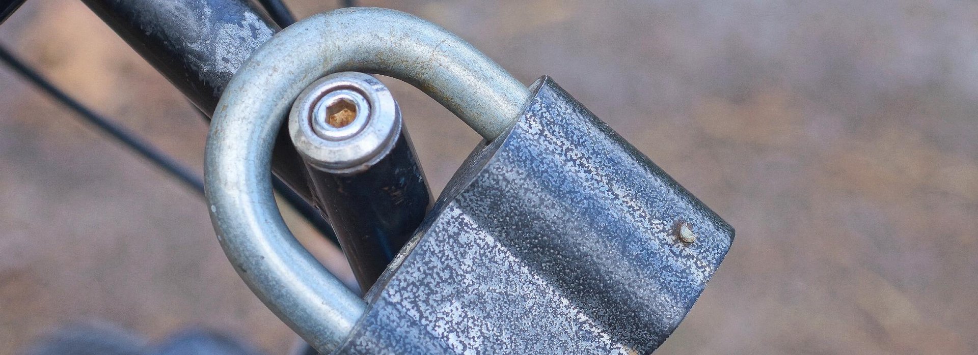 Ein B&uuml;gelschloss aus Eisen h&auml;ngt an einem Fahrrad.