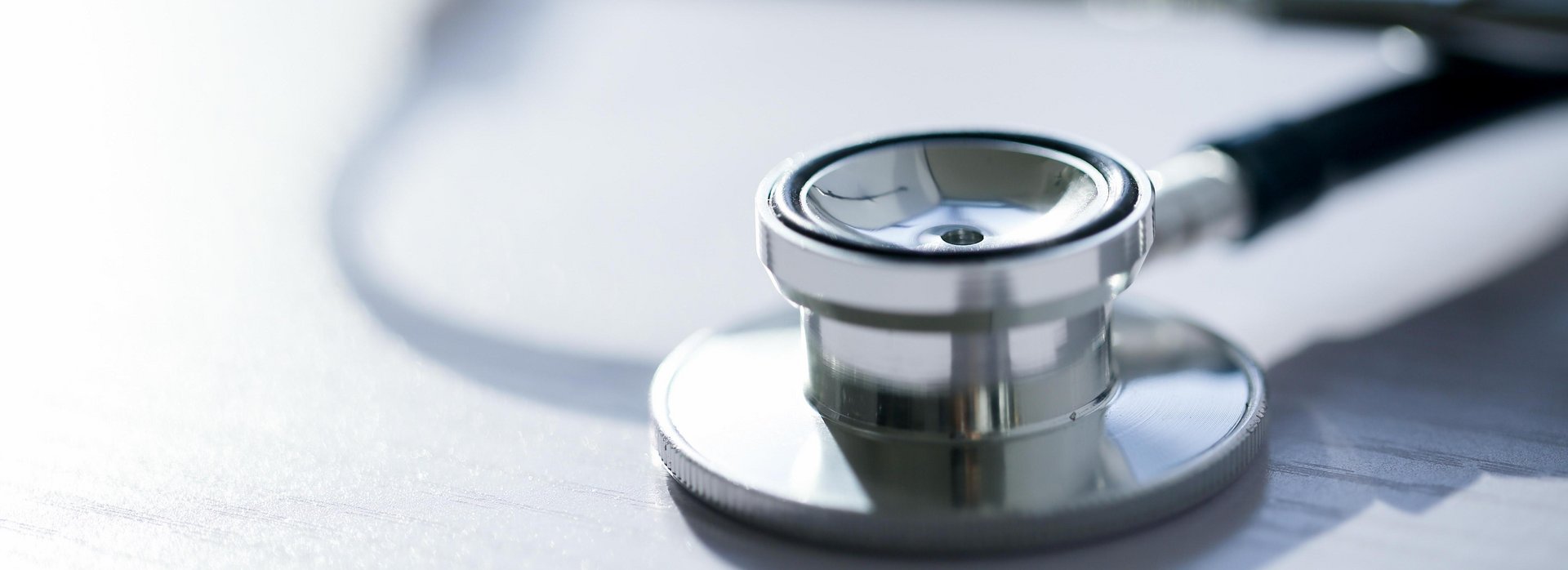 A stethoscope lies on a desk.