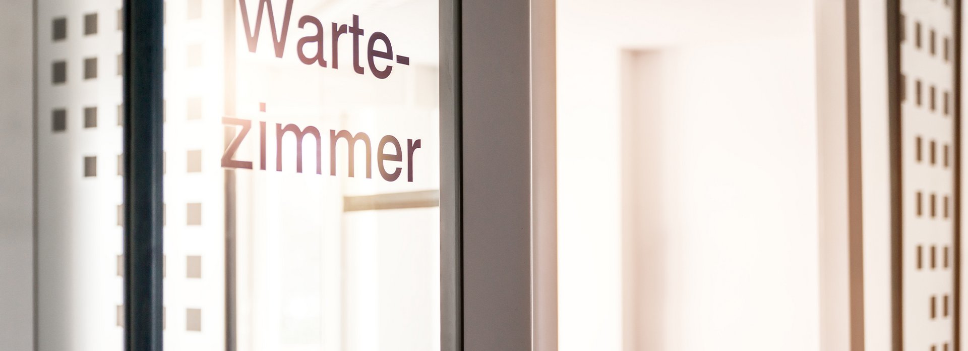 Das Bild zeigt eine T&uuml;r in einer Arztpraxis auf der "Wartezimmer" steht.